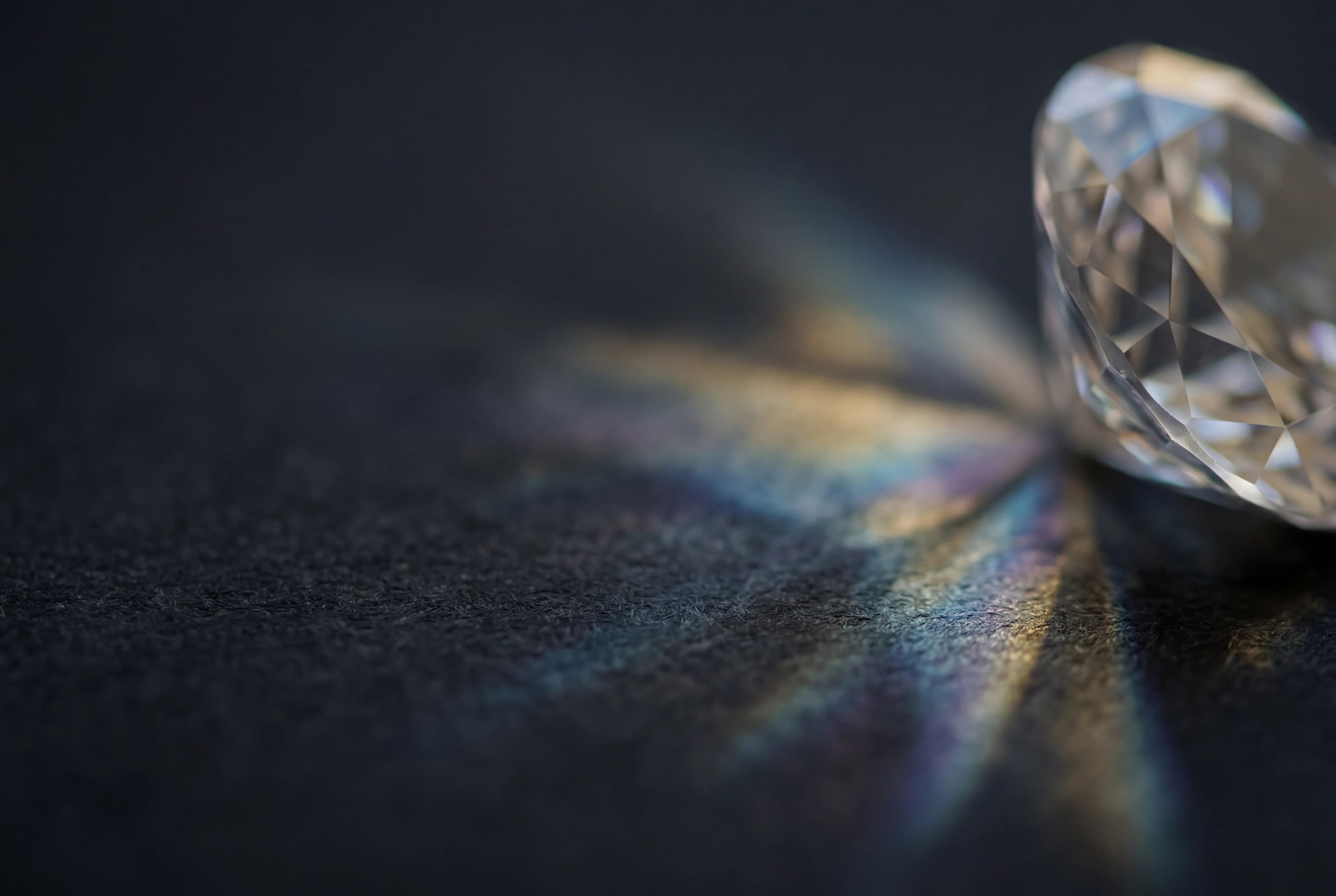 Loose diamond refracting light on a dark surface